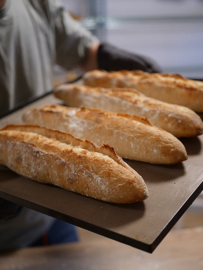 Håndlaget rustikk baguette med sprø skorpe og luftig smule, bakt med naturlig heving.