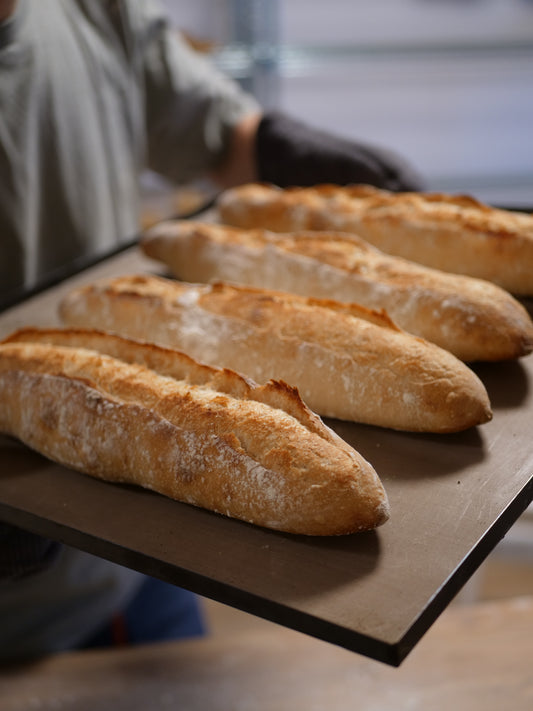 Håndlaget rustikk baguette med sprø skorpe og luftig smule, bakt med naturlig heving.