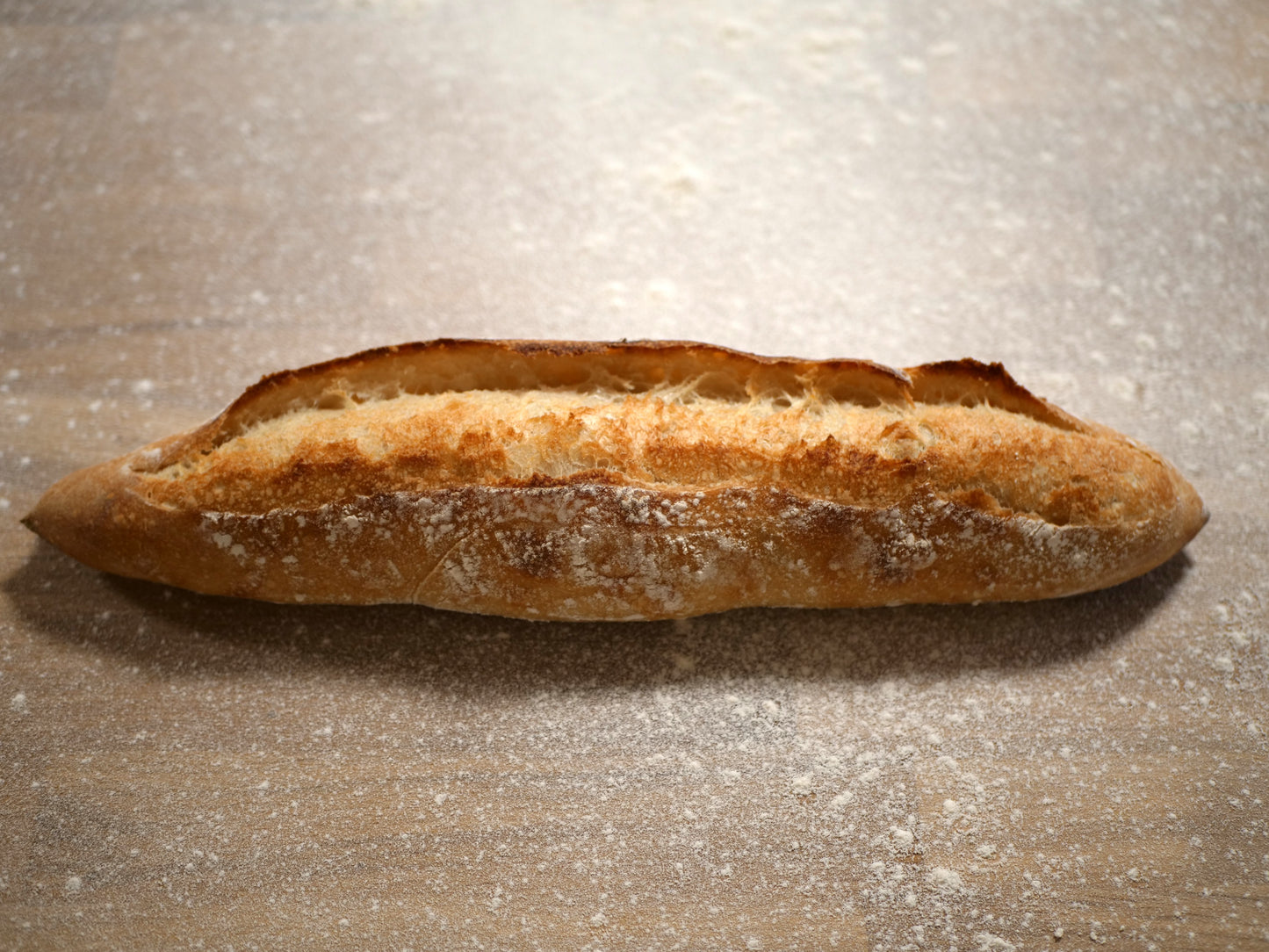 Håndlaget rustikk baguette med sprø skorpe og luftig smule, bakt med naturlig heving.