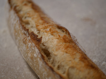 Håndlaget rustikk baguette med sprø skorpe og luftig smule, bakt med naturlig heving.