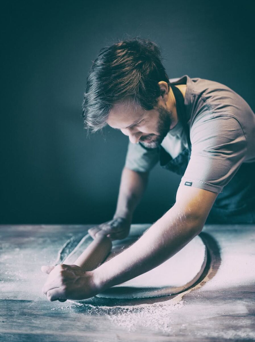 Adrian arbeider med deig på bakebordet